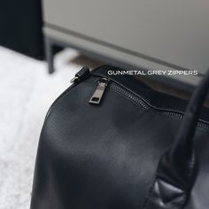 Designed to be minimal and understated, we've made a bag perfect for everyday use. It has an outer zip pocket, a grab handle, three inside pockets, and a leather shoulder strap. 52cm x 22cm (can be used as carry-on luggage) Includes shoulder strap Outer zip pocket perfect for accessories Two open inside pockets and one inside zipped pocket Made from vegan leather. Modern Weekender Shoulder Bag With Zipper, Modern Weekender Shoulder Bag With Zipper Closure, Modern Tote Duffle Bag With Zipper Closure, Black Leather Weekender Bag With Zipper, Modern Black Soft Leather Duffle Bag, Black Soft Leather Duffle Bag For Daily Use, Business Black Weekender Bag With Zipper, Black Soft Leather Weekender Bag For Business Trips, Business Black Weekender Bag With Zipper Closure