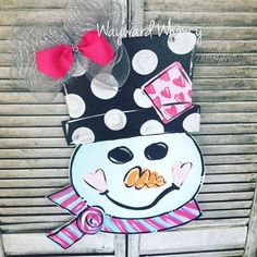 a snowman door hanger is decorated with polka dots and a bow on it