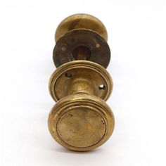 four antique brass door knobs on a white background