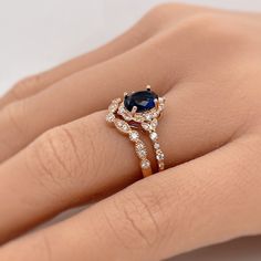 a woman's hand with a diamond and sapphire ring on top of her finger