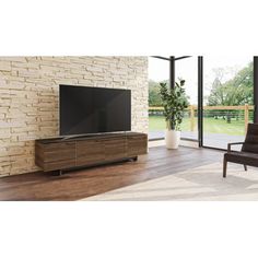 a large flat screen tv sitting on top of a wooden entertainment center in a living room