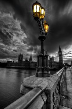 a street light sitting on the side of a bridge next to a body of water