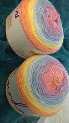 two skeins of yarn sitting next to each other on a blue blanket,