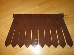 a piece of brown leather sitting on top of a wooden floor