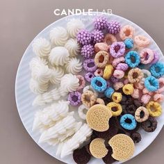 a white plate topped with lots of different types of cookies and doughnuts next to each other