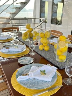 the table is set with lemons and glasses on it, along with other dishes