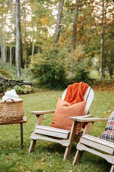 two wooden chairs sitting on top of a lush green field