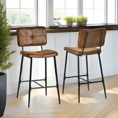 two brown barstools sitting next to each other on top of a hard wood floor