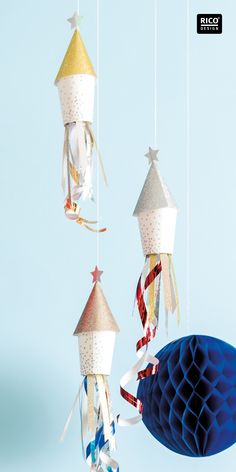 an origami mobile with stars and ribbons hanging from it's sides in front of a blue background