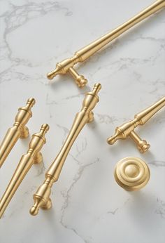 three golden handles and two knobs on a marble surface