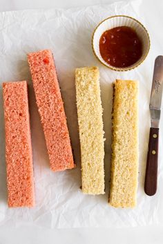 three pieces of cake sitting on top of a piece of paper next to a knife