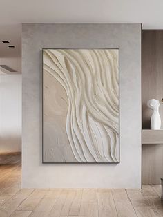 an abstract painting on the wall in a living room with wood flooring and white walls