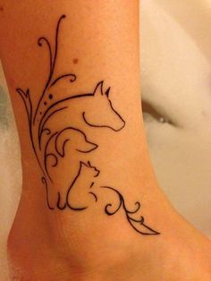 a woman's foot with a horse and dog tattoo on the side of her leg