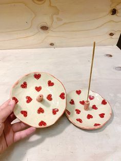 two small plates with hearts on them are being held by a person's hand