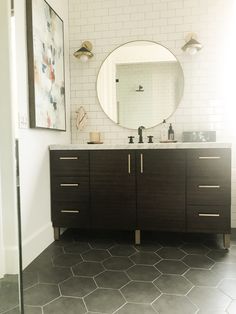 a bathroom with two sinks and a large mirror on the wall above it's counter