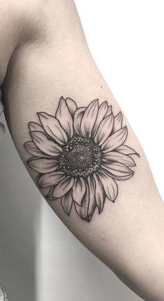 a black and white sunflower tattoo on the arm