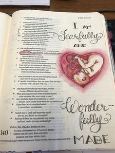 an open bible with handwritten text on the page and a drawing of a baby inside it