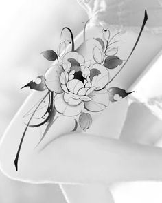 a black and white photo of a woman's arm with flowers on it