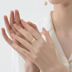 a woman is holding her hands together and wearing a ring with a diamond on it