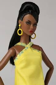 a barbie doll with black hair wearing yellow dress and large hoop earrings on her head