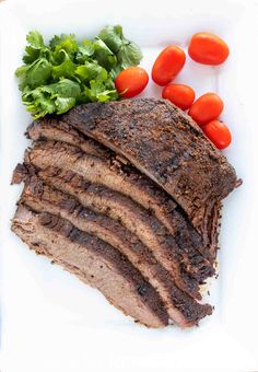 sliced meat, tomatoes and lettuce on a white plate