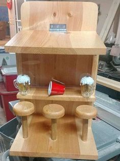 a wooden display case with beer mugs and other items in it on top of a workbench