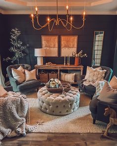 a living room filled with furniture and a chandelier hanging above the couches