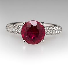 This pretty ring is centered with one (1) round modified brilliant cut natural tourmaline set into a four-prong head. The shank is accented with forty-six (46), bead set, round brilliant cut diamonds on each side. The side face of the ring are each accented with three (3), bead set, round brilliant cut diamonds. The ring measures 8.0mm at the top, rises 9.6mm above the finger, tapering to 2.3mm wide and 1.6mm thick at the base of the shank. Signed Gabriel & Co 14K S128023. It is currently a size 5. Luxury Ruby Ring With Gemstone Accents, Ruby Diamond Ring With Accent Stones And Round Cut, Diamond Ring With Center Stone And Lab-created Ruby, Exquisite Ruby Ring With Center Stone, Dazzling Ruby Ring With Brilliant Round Cut, Dazzling Brilliant Cut Ruby Ring, Dazzling Brilliant Cut Round Ruby Ring, Round Diamond Ring With Center Lab-created Ruby, Classic Ruby Ring With Gemstone Accents For Promise