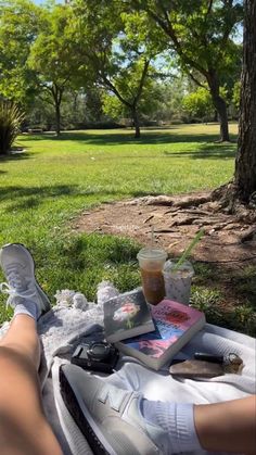 a person laying on top of a blanket next to a cup of coffee and book