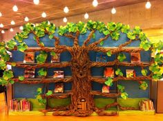 a tree with bookshelves on it and lights hanging from the ceiling