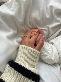 a person laying in bed with their hands clasped together