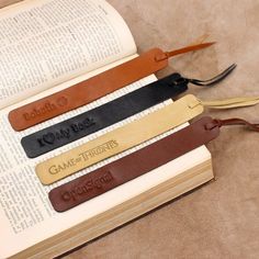 four leather bookmarks sitting on top of an open book