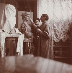 an old black and white photo of two women in front of a statue with a child on her lap