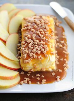 an enchilada on a plate with apples and caramel sauce