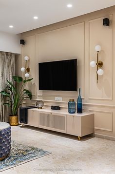 a living room filled with furniture and a flat screen tv on top of a wall