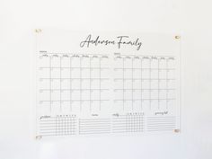 a calendar hanging on a white wall with the word anderson family written in cursive writing