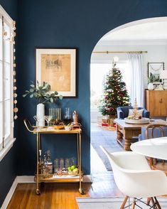 a living room with a christmas tree in the corner and other decorations on the table