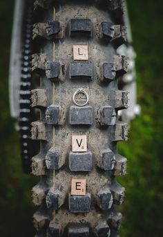 the word love spelled with scrabbles on a bike tire in front of some grass