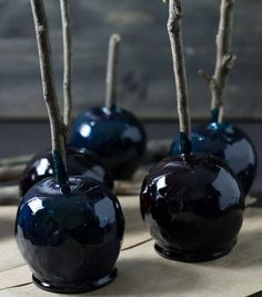 three blue apples with sticks sticking out of them