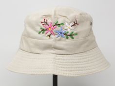 Item: flower embroidered bucket hat Material: 35% cotton, 65% polyester Size: one size fits most, brim measuring 2 inches long Embroidery: hand made with acrylic thread Free first class shipping, upgradable priority mail service. 30 days return policy, feel confident at your purchase! Outdoor Cream Cotton Bucket Hat, Cream Cotton Bucket Hat, Beige Summer Hats With Embroidered Logo, Cream Cotton Bucket Hat, One Size Fits Most, Cream Cotton Bucket Hat, One Size, Summer Embroidered Beige Hat, Cream Cotton Brimmed Hat, Cream Brimmed Cotton Hat, Cream Brimmed Cotton Bucket Hat