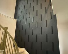 the wall is made up of black panels and white railings, along with a stair case