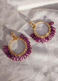 Beautiful, chic golden hoop style earrings that have purple pearl and golden pearls and mini-loop detailing. These earrings are curated with high-quality stainless steel material. Purple Dangle Hoop Earrings, Pink Small Hoop Metal Jewelry, Purple Metal Beaded Drop Earrings, Trendy Purple Metal Earrings, Purple Metal Earrings With Dangling Beads, Gold Beaded Circle Earrings, Gold Brass Hoop Earrings With Dangling Beads, Small Hoop Metal Earrings With Dangling Beads, Small Hoop Metal Jewelry With Dangling Beads