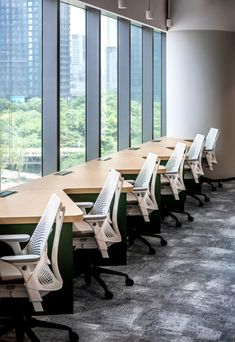 an empty conference room with chairs and tables in front of large windows overlooking the city