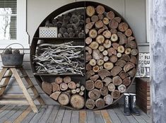 there are many logs stacked on the outside of this round rack that is made out of wood