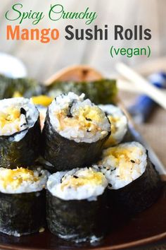 some sushi rolls are on a plate with chopsticks next to it and the title says spicy crunch mango sushi rolls vegan