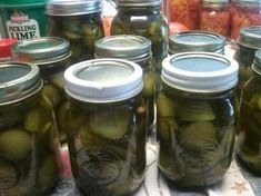 several jars filled with pickles sitting on top of a table