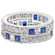 a blue and white diamond ring with two rows of diamonds in the middle, set on top