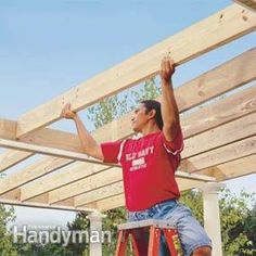 a man standing on a ladder working on a wooden structure with his hands in the air