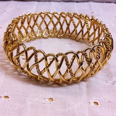 This beautiful piece is a Goldtone Metal Braided Wire Bracelet. No maker's mark found. Used but in great condition. Diameter of the piece is approximately 2 3/4 inches and width is approximately 1 inch. Metal Stretch Bangle For Formal Occasions, Formal Metal Stretch Bangle, Formal Gold Metal Stretch Bracelet, Vintage Gold Stretch Bracelet As Gift, Adjustable Gold Bangle In Costume Jewelry Style, Vintage Gold Stretch Bracelet For Gift, Vintage Gold Stretch Bracelet Gift, Adjustable Gold Bangle Costume Jewelry, Adjustable Gold Costume Jewelry Bangle