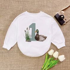 One Lucky Duck Birthday Romper, Mallard Duck Birthday Baby Romper, Duckling Bodysuit,  Romper Sweatshirt, Trending Animal Shirt - Handmade  - Ships from USA  - Materials: 100% CPSIA Compliant and Ethically Made material Light fabric (5.0 oz/yd² (170 g/m  Crafted with soft, breathable fabric, this romper ensures your baby stays comfortable through playtimes and nap times alike. Featuring charming designs suitable for all babies, our romper is as adorable as it is practical.  Quick Sizing Tip  Our Family Matching Long Sleeve Tops With Character Print, First Birthday Crew Neck Top With Character Print, Playful Cartoon Print Tops For First Birthday, Playful Tops With Cartoon Print For First Birthday, Long Sleeve Tops With Cartoon Print For Birthday, Crew Neck Top With Cartoon Print For First Birthday, Graphic Print Long Sleeve Top For First Birthday, Family Matching Long Sleeve Birthday T-shirt, Long Sleeve Cartoon Print T-shirt For Birthday